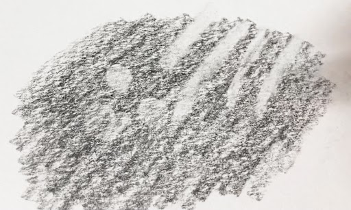 鉛筆で塗られた下地に、消しゴムで、線の形と点の形に白く消したあとが残っている。